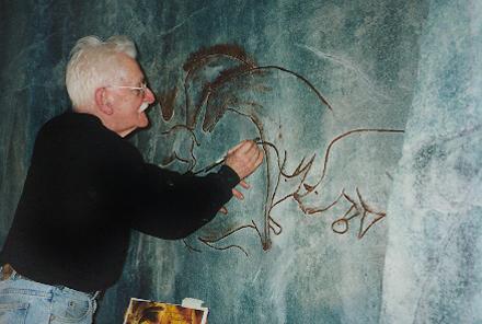 An artist paints on the walls of the indoor waterfall